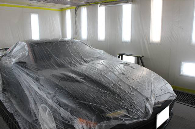 塗装ブースで塗装作業中の車